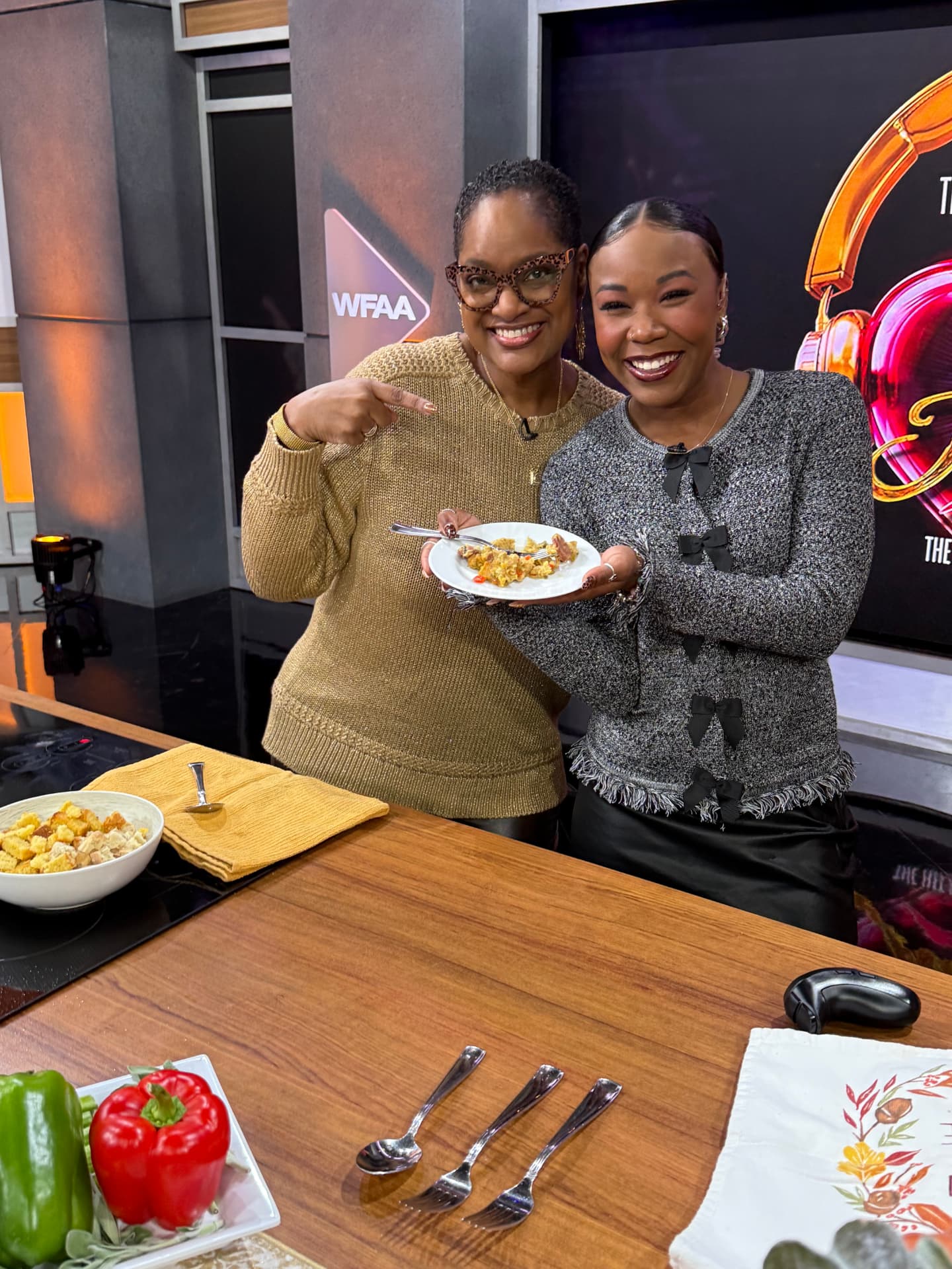 Chef Lorious and a host smiling over a plate of Thanksgiving cornbread dressing