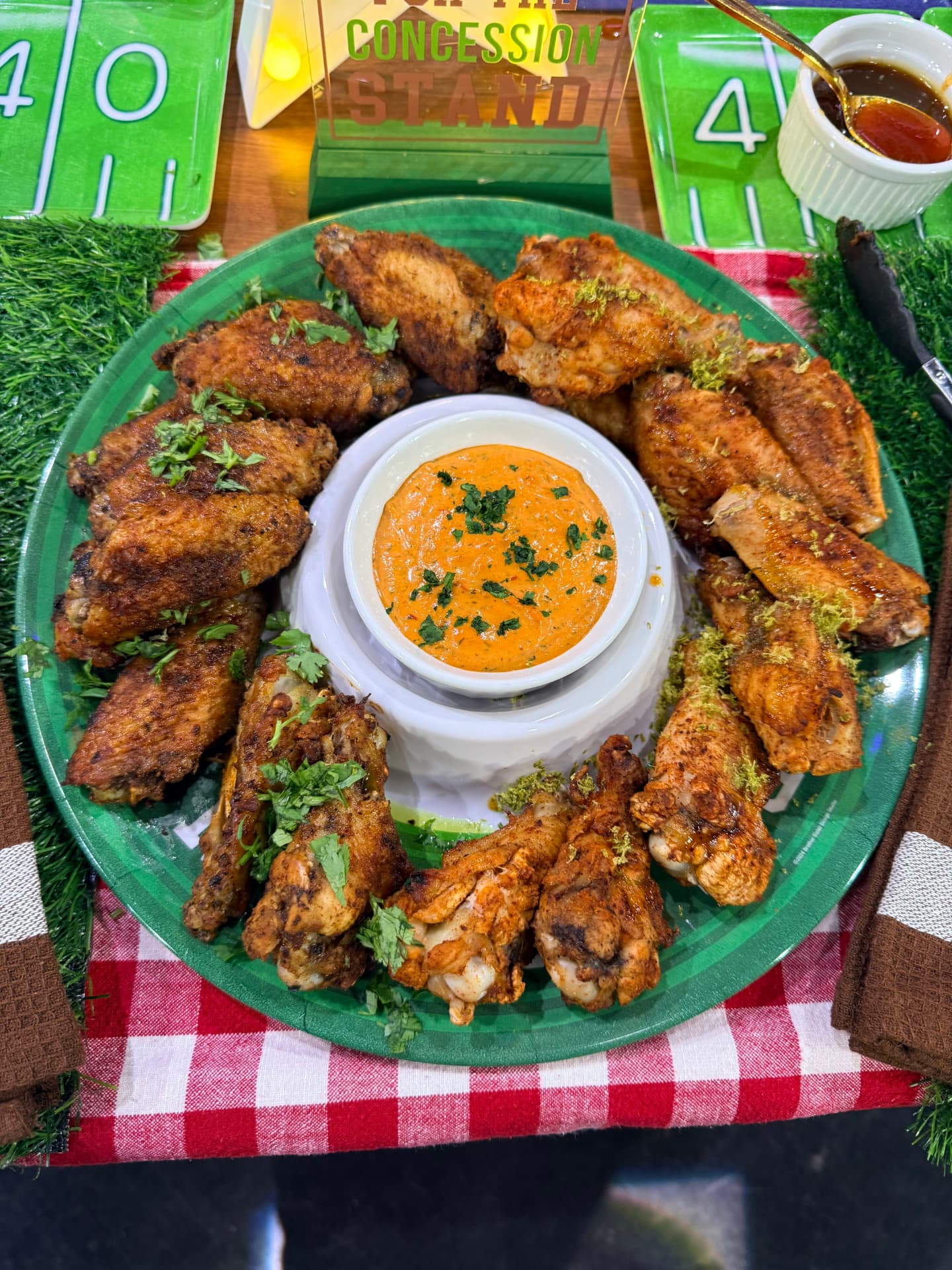 Game day wings arranged around a dip on a football-themed table
