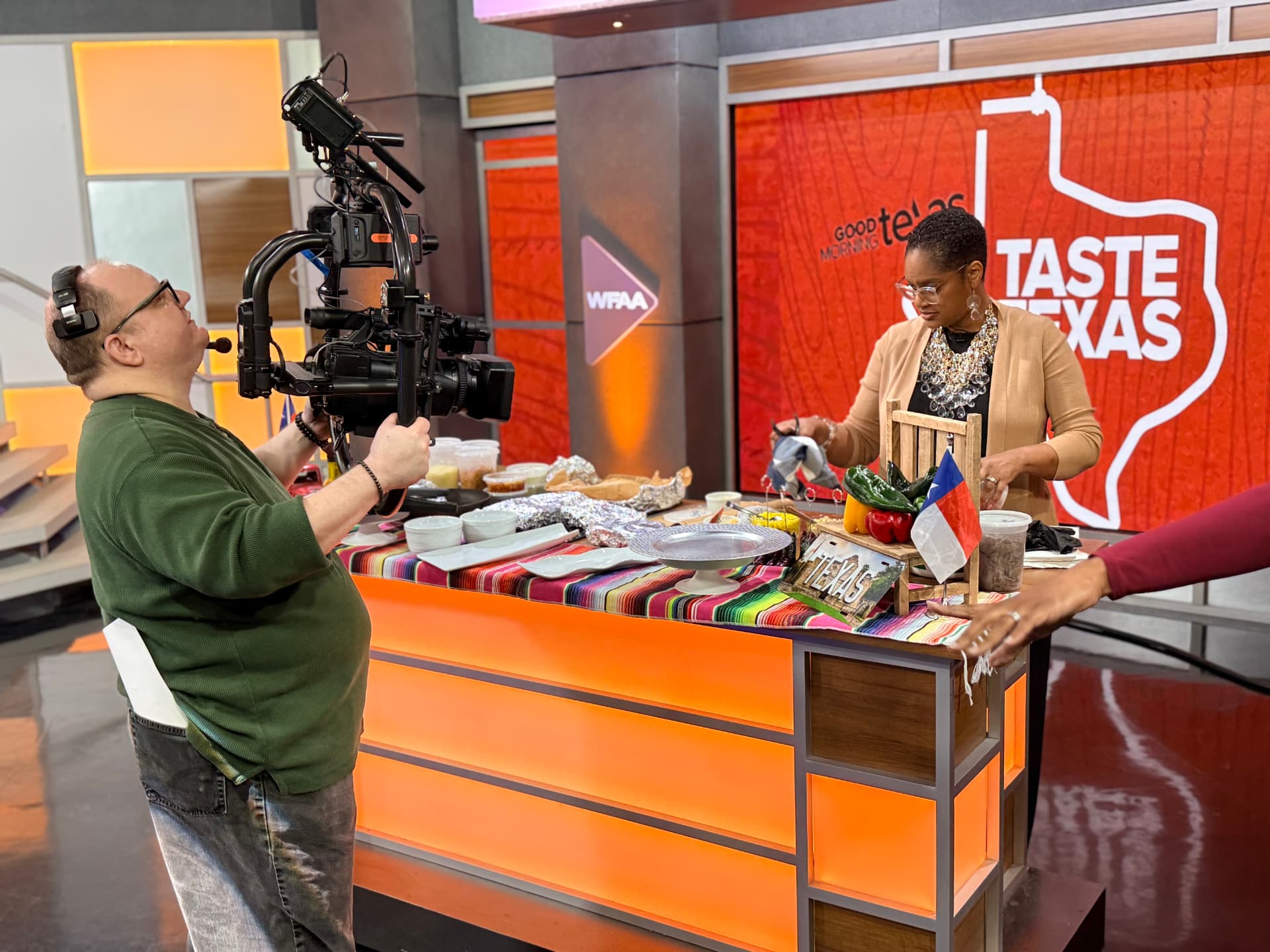 Chef Lorious setting up her Taste Texas table while a camera operator films