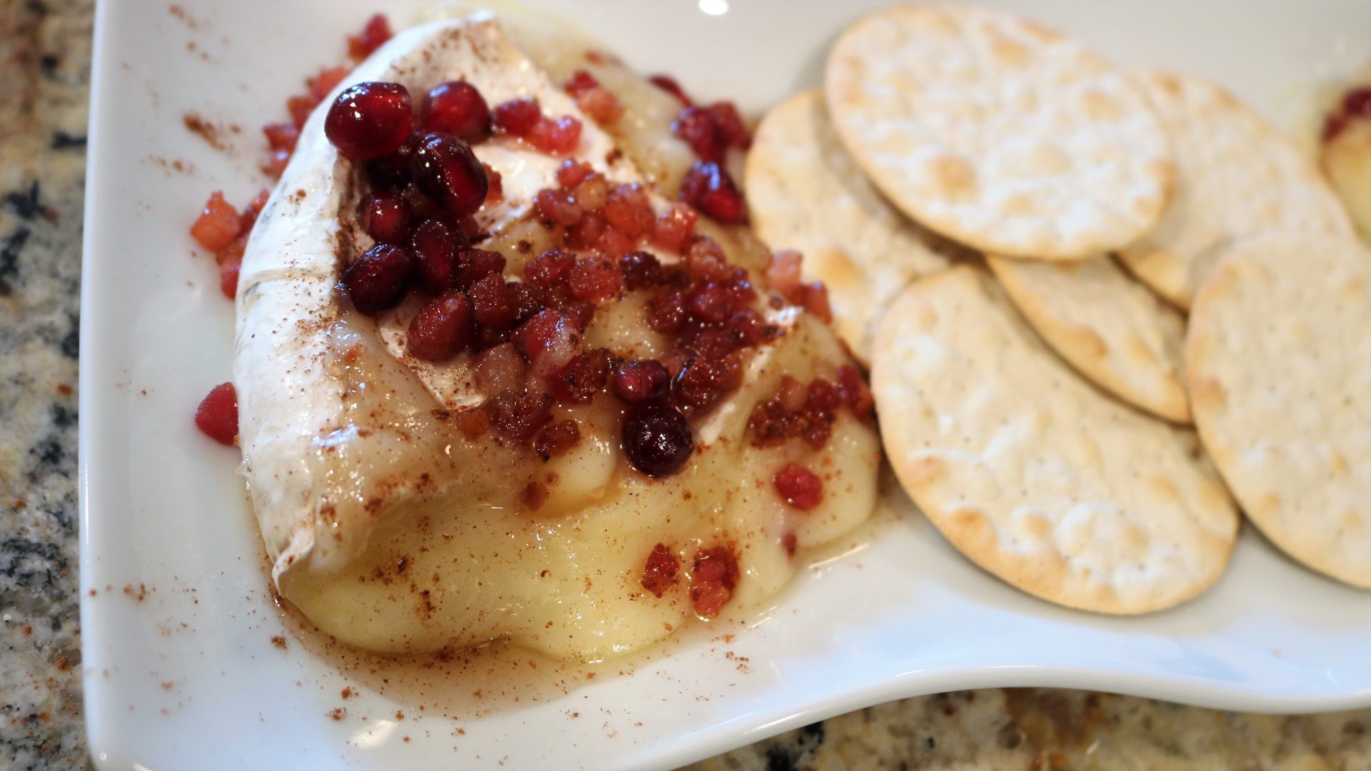 A plate of food with crackers and cranberry sauce.
