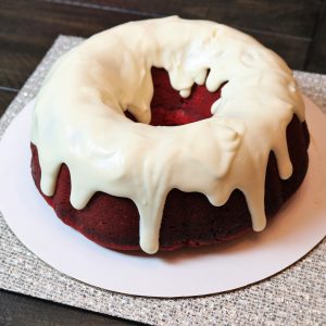 A red velvet cake with white frosting on top.