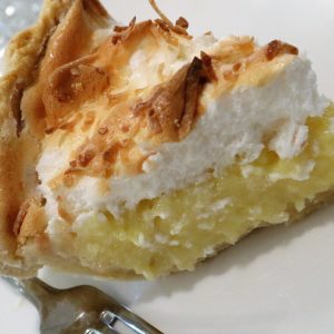 A piece of pie with coconut on top.