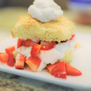 A white plate topped with cake and strawberries.