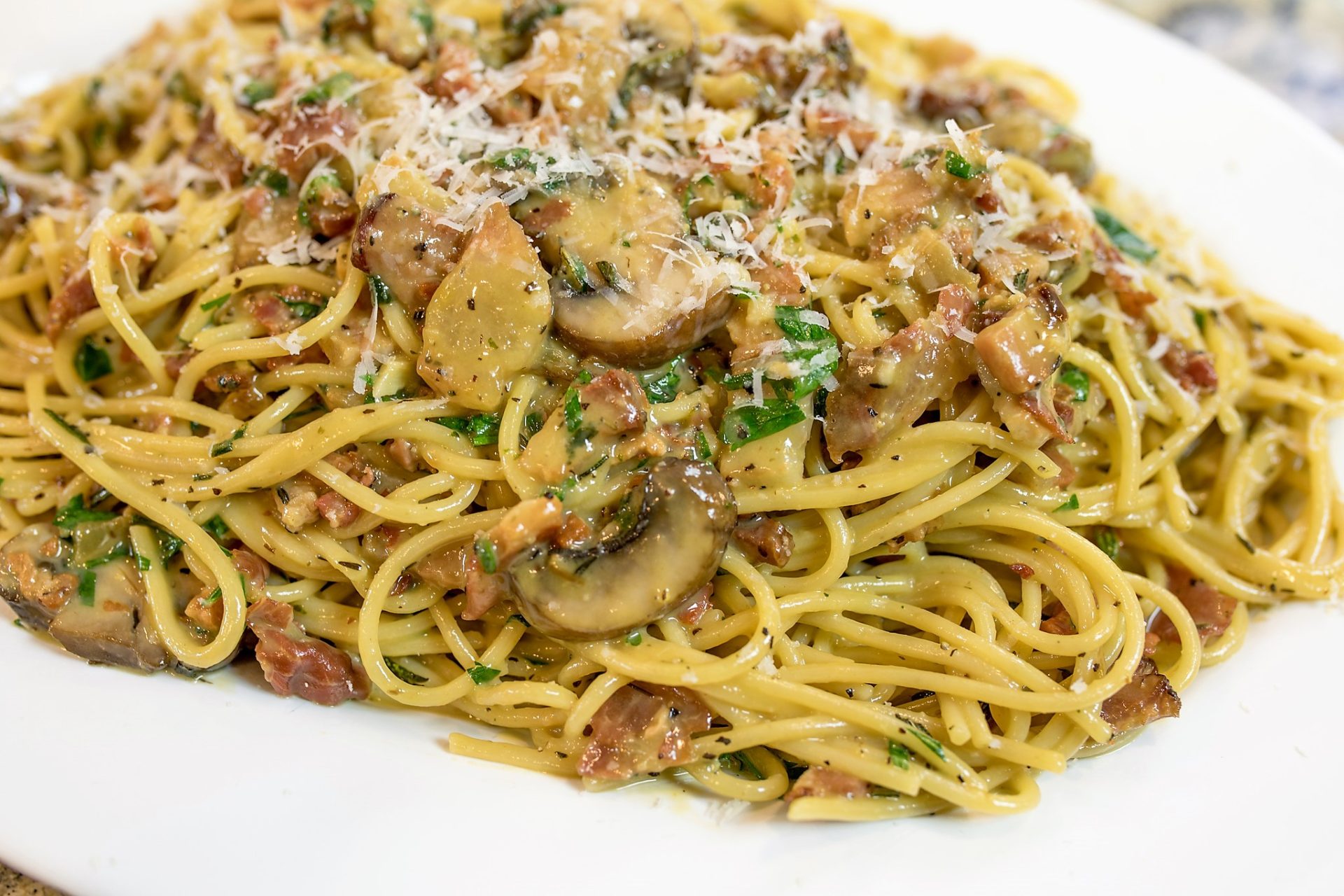 A plate of pasta with mushrooms and meat.