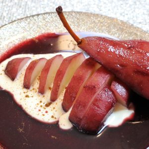A plate of food with pears and sauce.