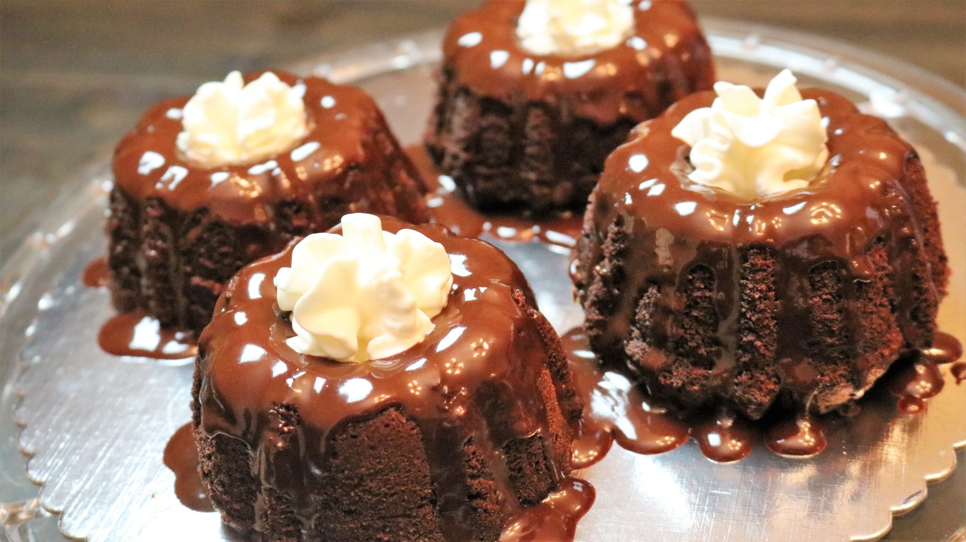 A plate of chocolate cakes with white frosting.