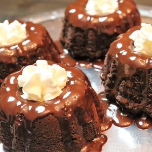 A plate of chocolate cakes with white frosting.