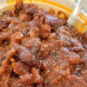 A bowl of chili with a fork in it.