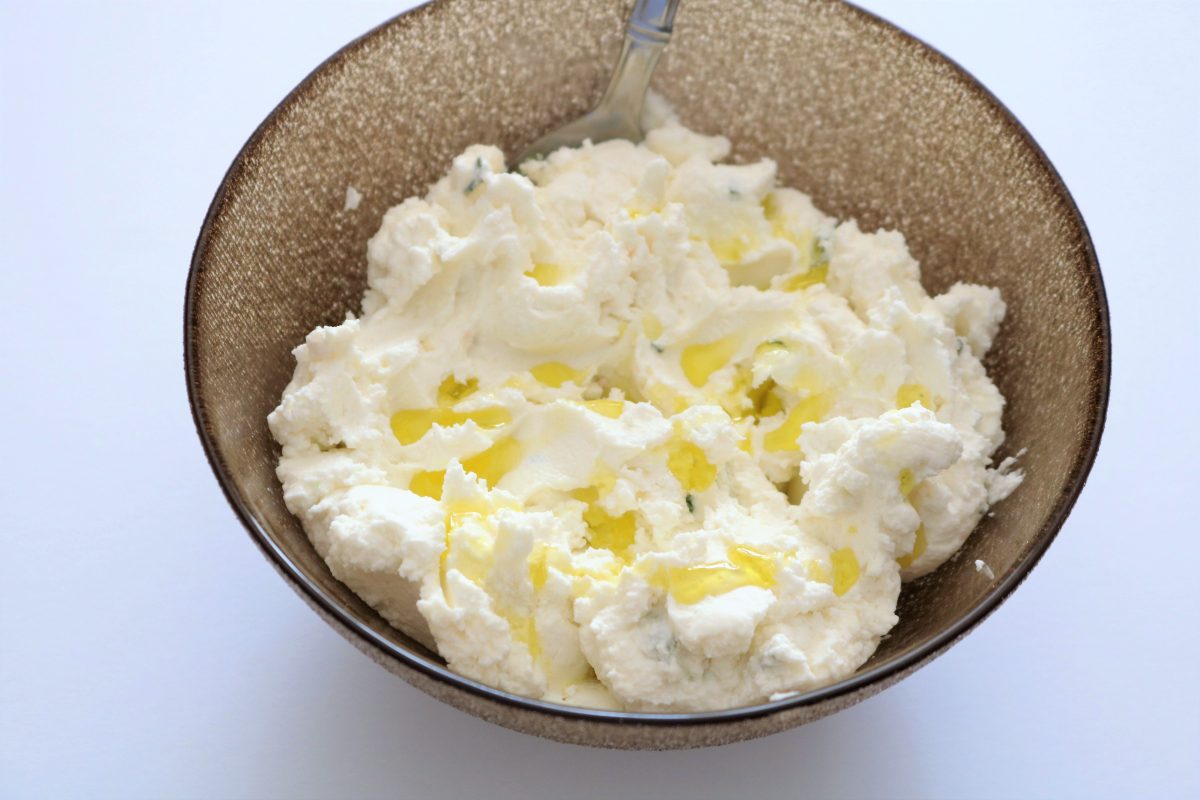A bowl of mashed potatoes with a fork in it.