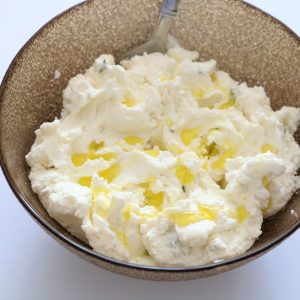 A bowl of mashed potatoes with a fork in it.