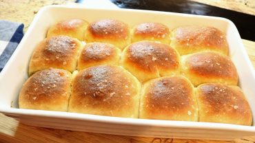 A pan of bread rolls with sea salt on top.
