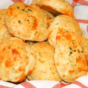 A plate of biscuits with cheese on top.