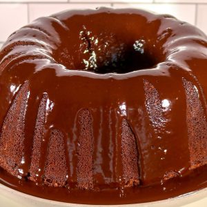 A chocolate bundt cake with melted chocolate on top.