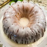 A bundt cake with white icing on top of a plate.