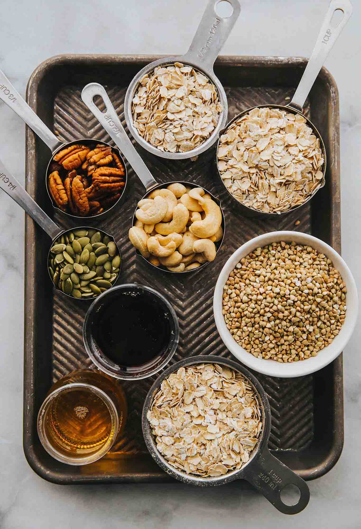 A tray with nuts, seeds and other foods on it.